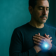 Hombre de unos 40 años junto a una ventana en una práctica de protección energética con las manos cruzadas sobre el pecho