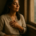 Escuchar tu intuición: mujer serena con la mano en el pecho junto a una ventana al amanecer, en silencio interior