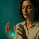Mujer junto a una ventana aprendiendo a sentir tu energía con las palmas enfrentadas frente al pecho