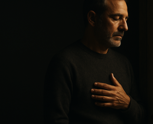 Personas despiertas sufren más: hombre sereno con la mano en el pecho, luz penetrando la penumbra