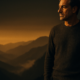 Hombre en cumbre de montaña al atardecer dorado representando lograr resultados Método 5L desde la calma