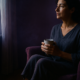 Mujer cuidadora descansando junto a una ventana, recuperando energía — cansancio crónico sin causa médica