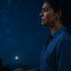 Ritual energético de cierre de mes: mujer serena cerrando una puerta al anochecer bajo una luna azul