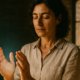 Mujer con las manos frente al pecho en una formación energética presencial en una masía de Vic