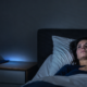 Mujer despierta de madrugada en la cama por cortisol y estrés crónico sostenido