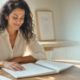 Mujer leyendo un manual de ejercicios en una mesa soleada: curso de energía presencial Valencia